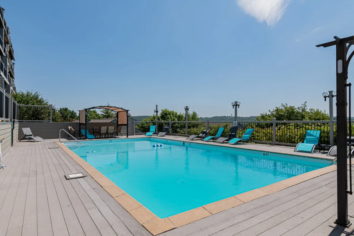 An inviting outdoor swimming pool is surrounded by lounge chairs and a shaded cabana area, creating a perfect setting for family fun and relaxation under the sun.