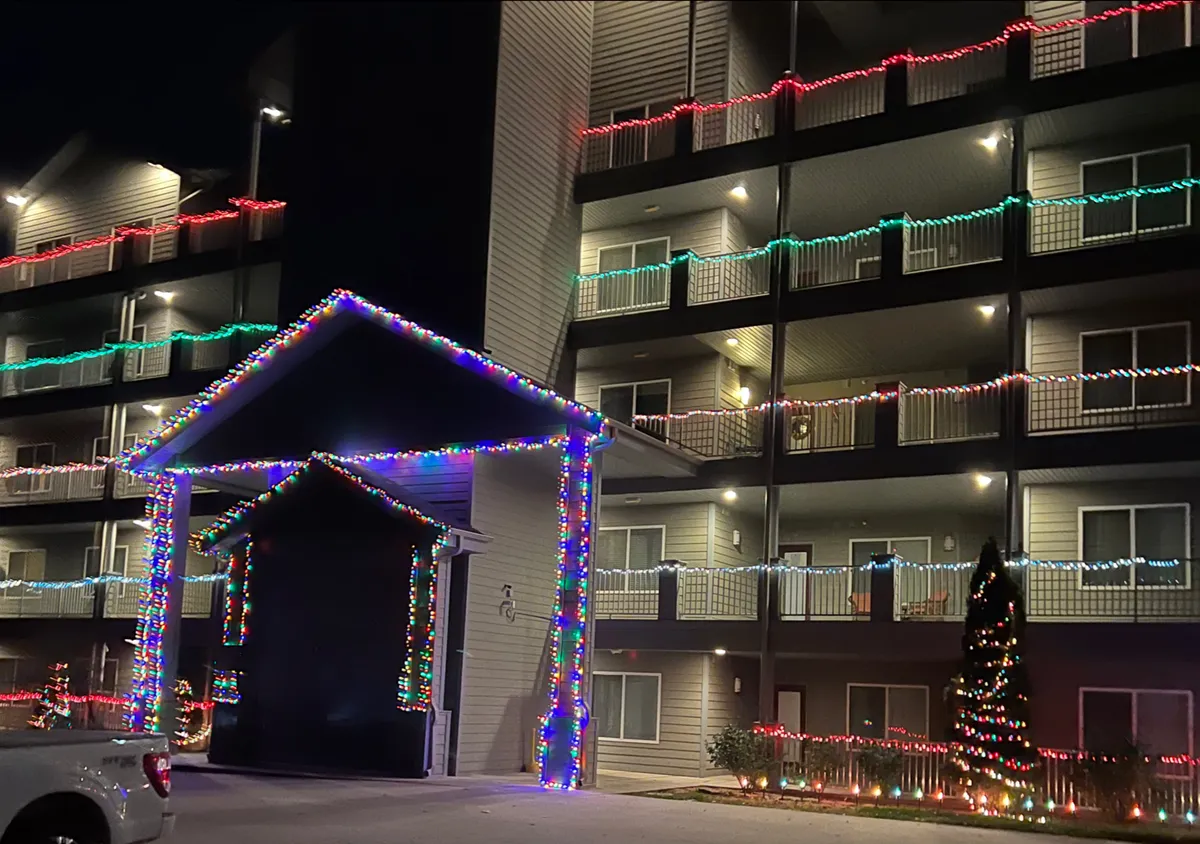 A festive exterior with colorful string lights, decorated balconies, and a lively entrance. The joyful mood evokes celebrations, group outings, and memorable evenings after Branson’s live shows or nightlife experiences.