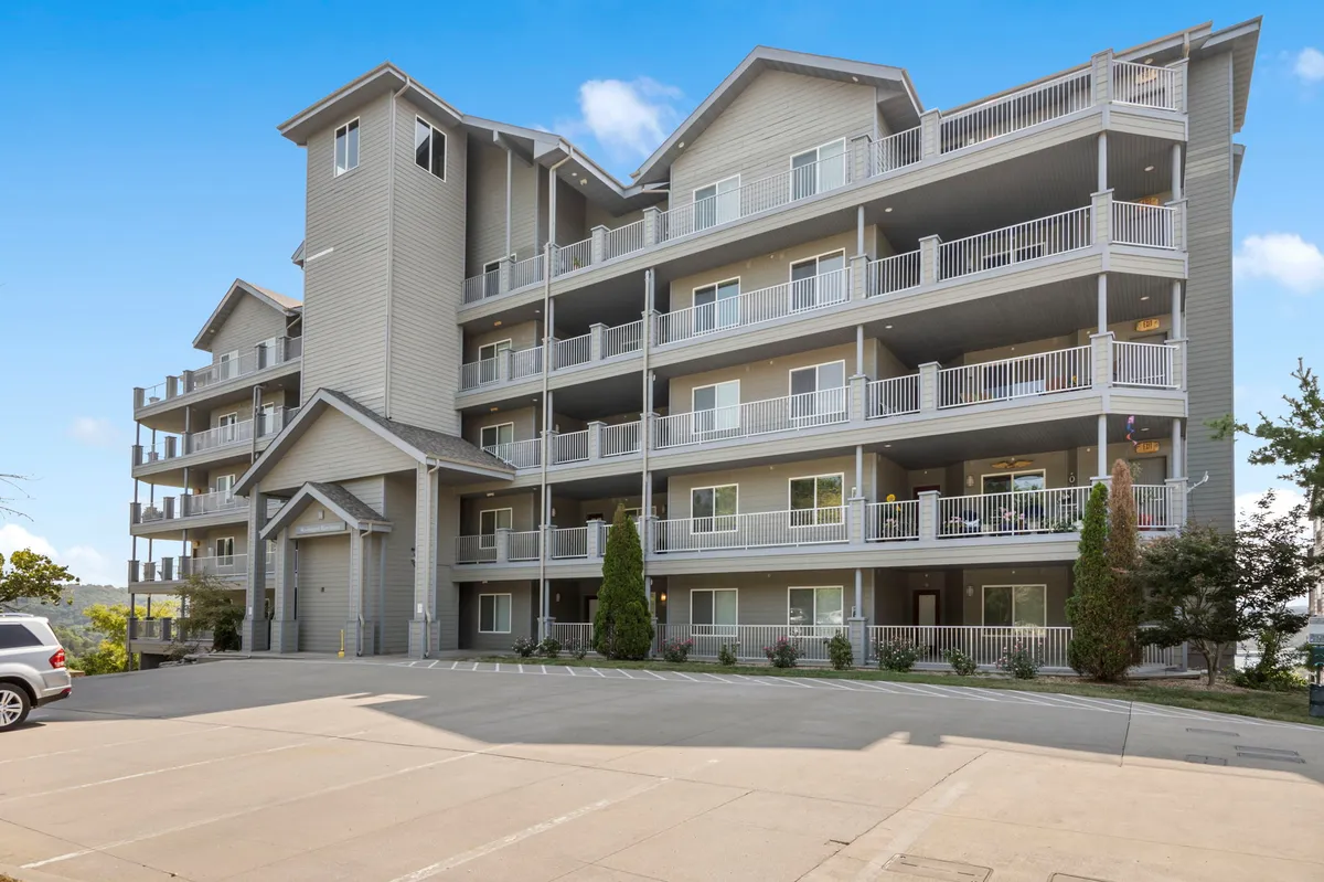 An inviting view of the building’s facade with balconies and lush landscaping, showcasing the proximity to nature and the ease of accessing outdoor adventures. The image emphasizes the connection between indoor comfort and the surrounding environment.