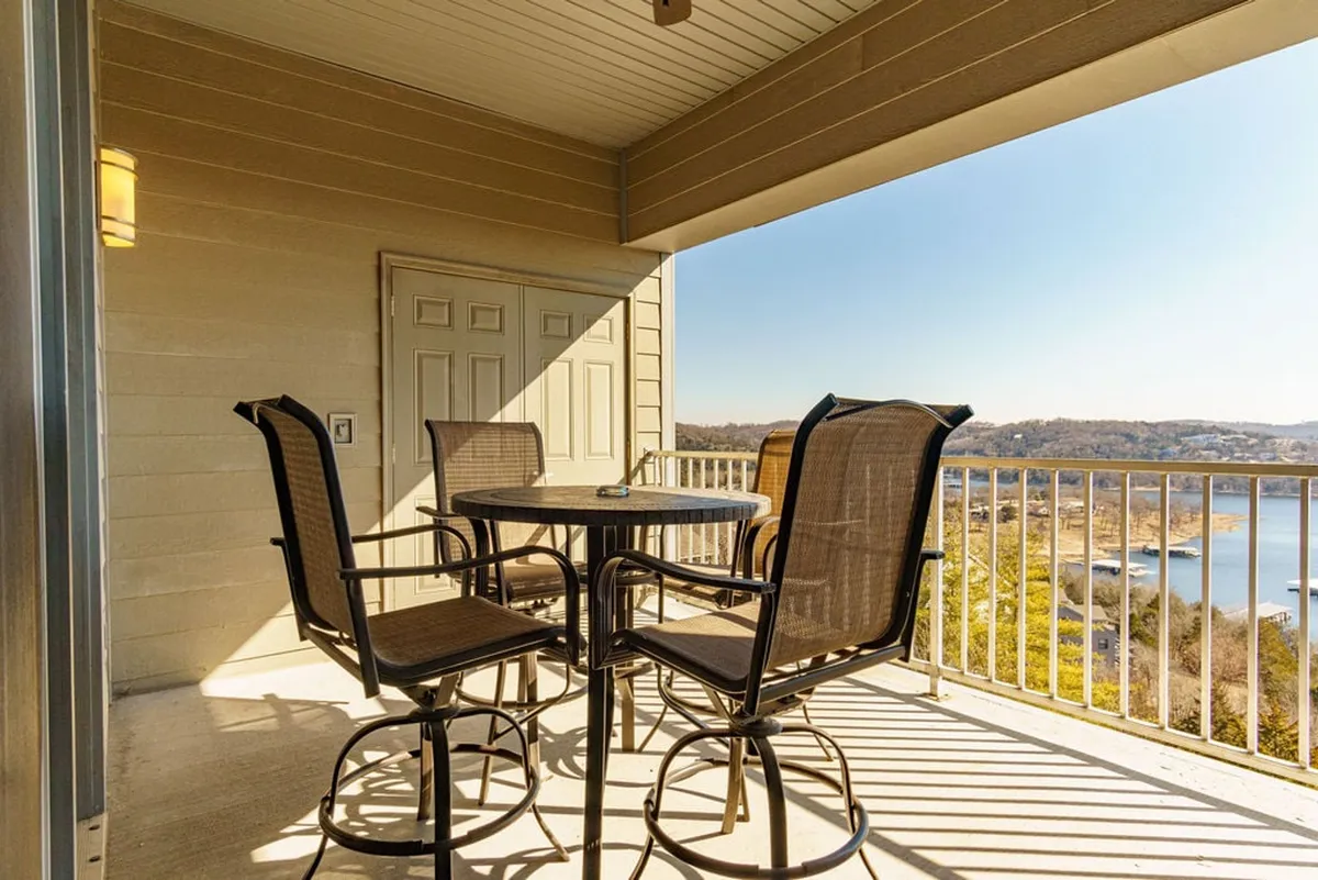 A cozy outdoor seating area with comfortable chairs facing the water, doors leading inside, and soft natural light. The setting is perfect for enjoying coffee at sunrise, relaxing at sunset, or intimate conversation.