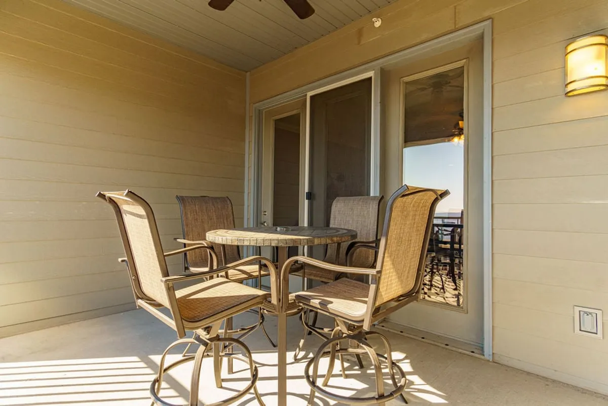 A round dining table with four chairs sits beside a sliding glass door, allowing glimpses of the deck and outdoors. The space feels relaxed and bright, ideal for both casual dining and enjoying the views beyond.